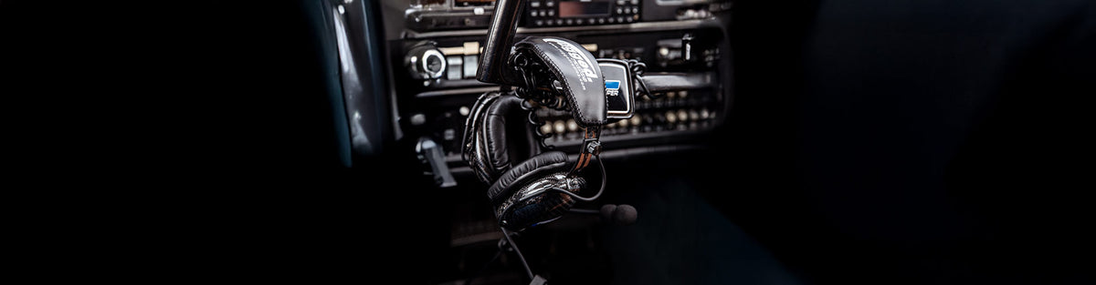 General aviation pilot headsets with noise‑reducing ear cups, boom mic, Bluetooth/ANR options, and carrying bag